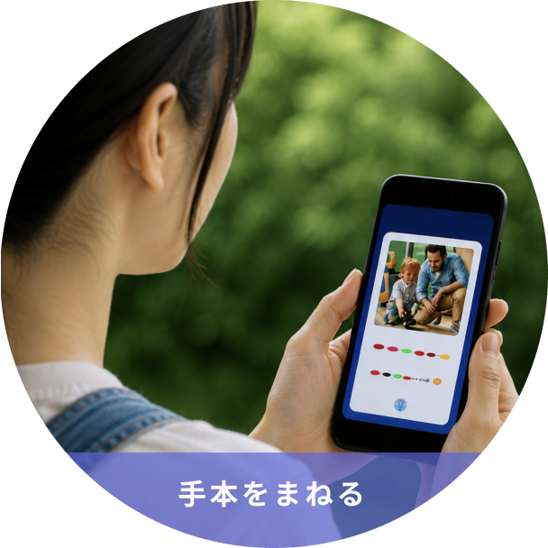 Person outdoors holding a smartphone showing a tutorial image with the banner text 手本をまねる in blue at the bottom of the screen.